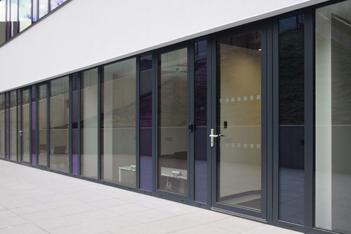 Okna i drzwi wejściowe aluminiowe na parterze nowoczesnego budynku